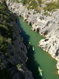 High angle view of people on canoeing in river amidst rock formations