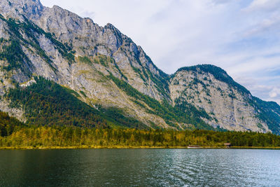 Scenic view of lake by mountains against sky