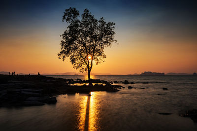 Silhouette people and tree with motion seascape at sunset of koh kwang island in krabi, thailand