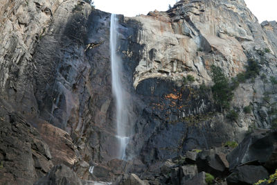 Low angle view of waterfall on rocks