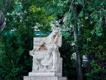 Statue amidst trees against plants