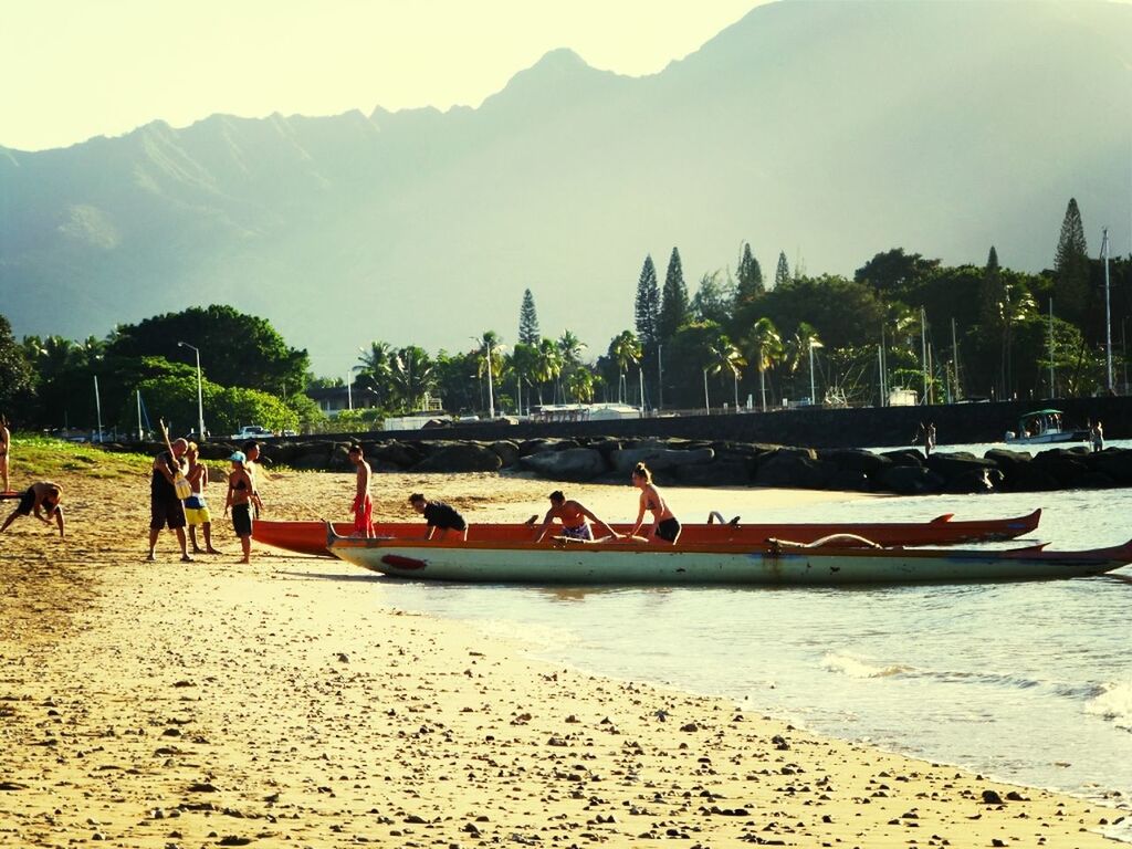 water, beach, mountain, sand, large group of people, leisure activity, lifestyles, vacations, nautical vessel, tree, men, shore, scenics, sea, tranquil scene, sky, person, tranquility, tourist