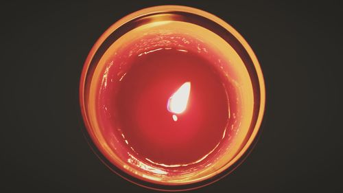 Close-up of illuminated red light over black background