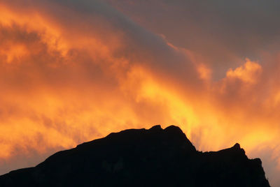 Low angle view of silhouette mountain against dramatic sky