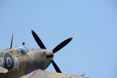 Low angle view of fighter plane against clear blue sky