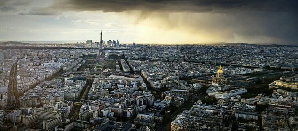 View of cityscape against cloudy sky