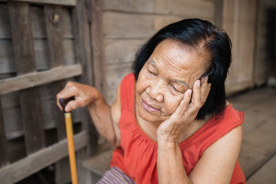 Close-up of senior woman with closed eyes sitting outdoors