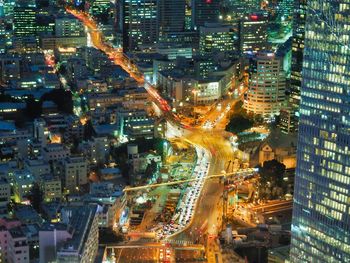 High angle view of illuminated street amidst buildings in city