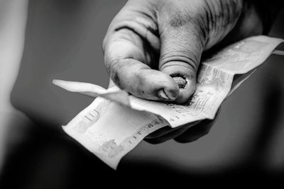 Cropped image of poor man holding indian currency