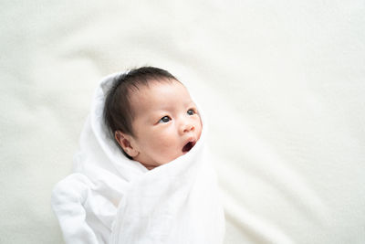 Portrait of cute baby girl on bed