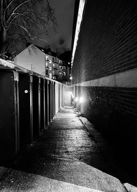 Illuminated street amidst buildings in city at night