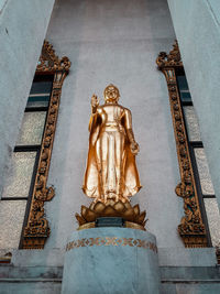 Low angle view of statue against temple building