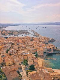 High angle view of townscape by sea against sky