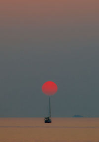 Fishing boat on sea against sky at dusk