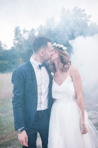 Newlywed couple kissing at park