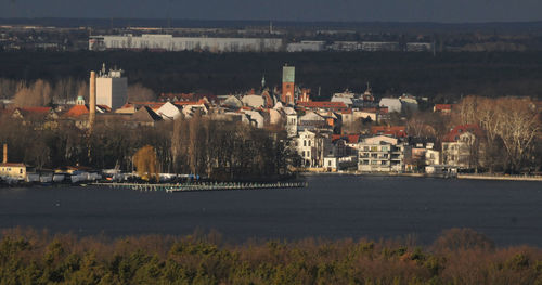 High angle view of buildings by river against sky