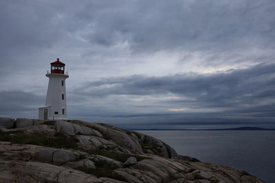 Lighthouse by sea against sky