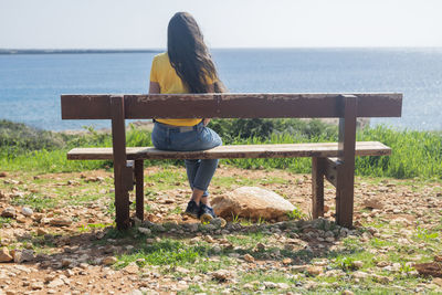 Rear view of woman sitting on field