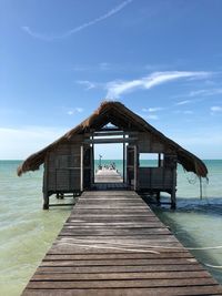 Wooden pier on sea against sky