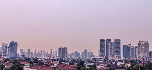 Modern buildings in city against clear sky