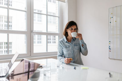 Woman standing by window on table