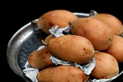 High angle view of papayas in plate against black background