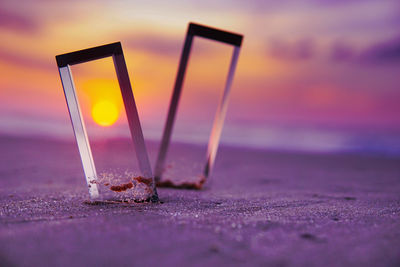 Close-up of water on table at beach during sunset