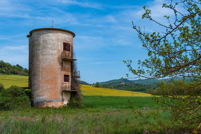 Built structure on field against sky