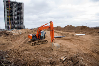 Red excavator during earthworks at construction site. backhoe digging the ground for the foundation