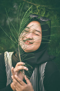 Portrait of woman holding plant