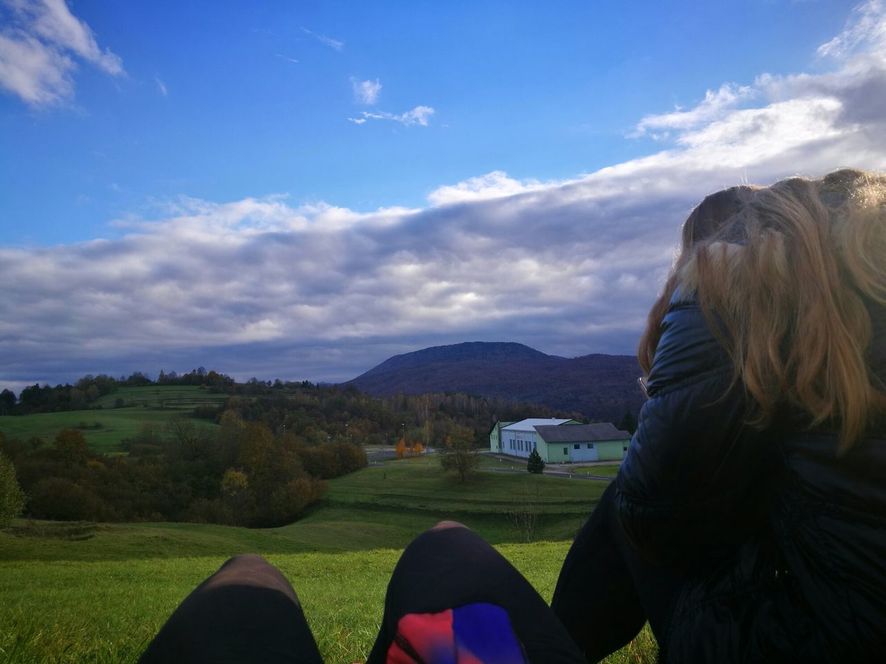 sky, cloud - sky, mountain, scenics, leisure activity, beauty in nature, nature, blue, one person, mountain range, rear view, outdoors, real people, rural scene, landscape, tranquility, women, grass, day, people, human body part, adults only, adult, human hand