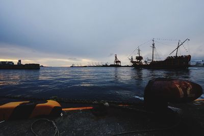 Boats moored at harbor against sky during sunset