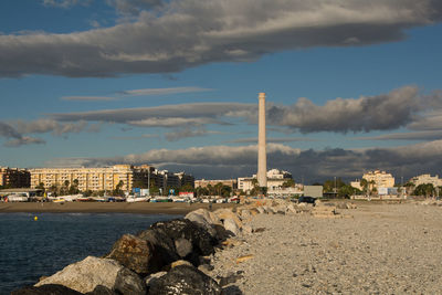 Scenic view of sea by city against sky