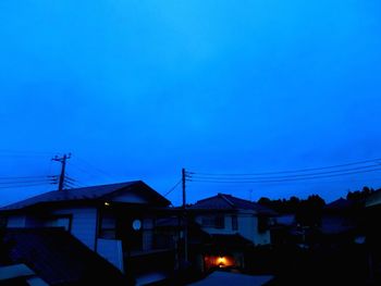 Illuminated buildings against clear blue sky at dusk