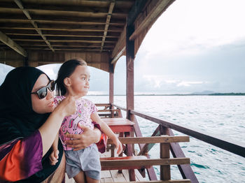 Mother with daughter looking at view from boat