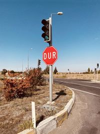 Road sign against clear blue sky