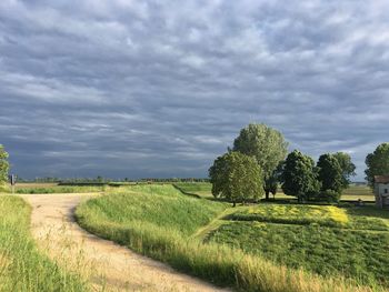 Scenic view of grassy field against cloudy sky