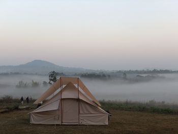 Tent on field against sky during foggy weather