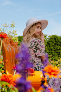 Young woman standing by flowering plants