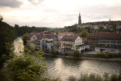 River amidst buildings in town against sky