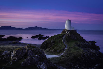 Lighthouse by sea against sky