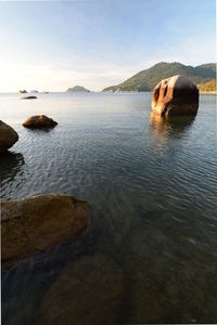 Scenic view of rocks in sea against sky
