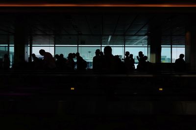 Silhouette people waiting at railroad station platform