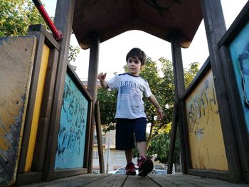 Full length of boy standing against built structure