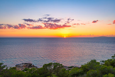 Scenic view of sea against romantic sky at sunset