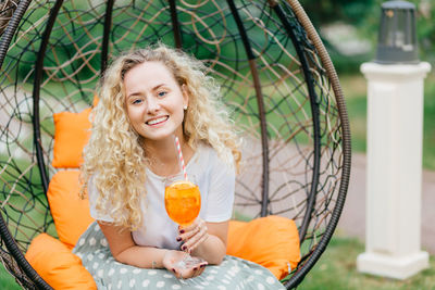 Portrait of a smiling woman sitting on glass