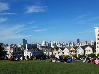 People in grassy park by the painted ladies.