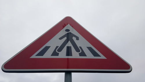 Close-up of road sign against sky