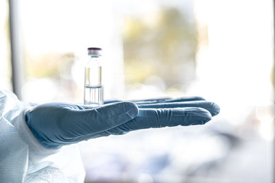 Close-up of scientists hand holding vial