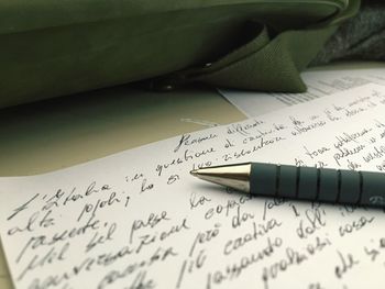 Close-up of pen and paper with text on desk